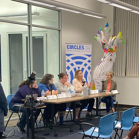 a panel of women sitting in a row behind a table